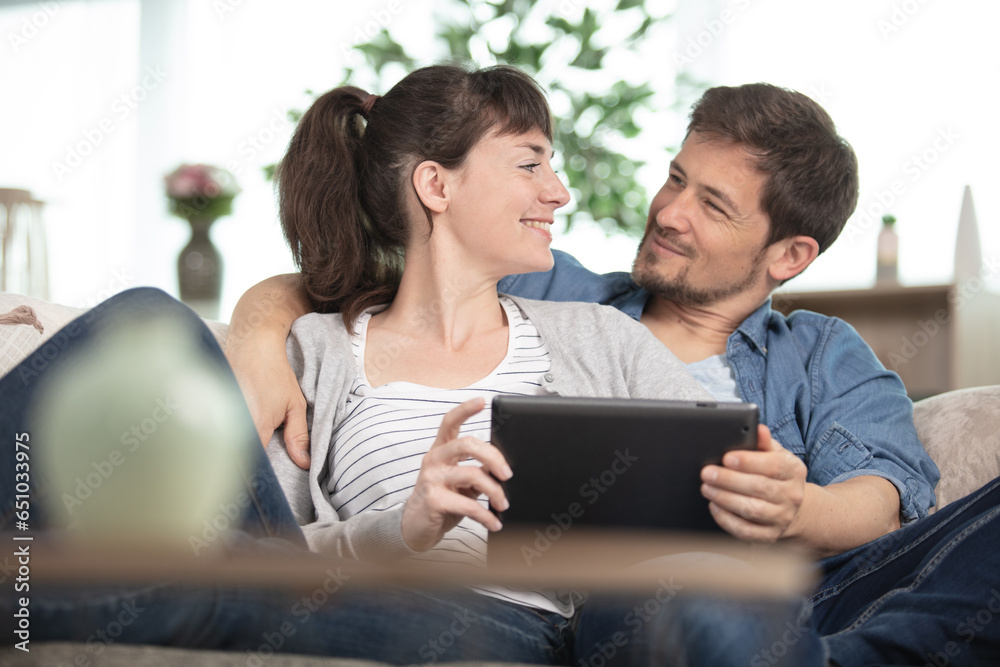 affectionate couple on the sofa using a tablet affectionate couple on the sofa using a tablet