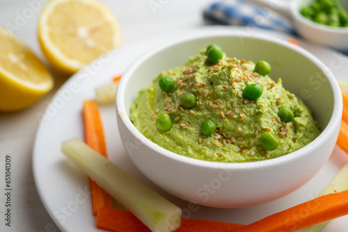 Green pea hummus served with carrot and cucumber.