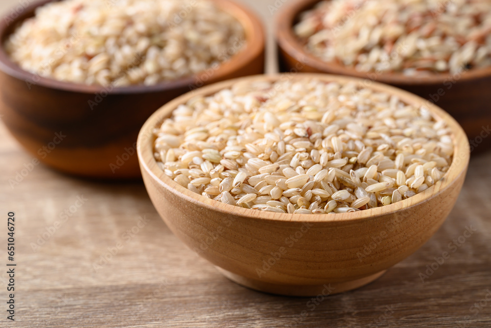 Thai brown rice seed in wooden bowl, Organic rice, Healthy food ingredient Thai brown rice seed in wooden bowl, Organic rice, Healthy food ingredient