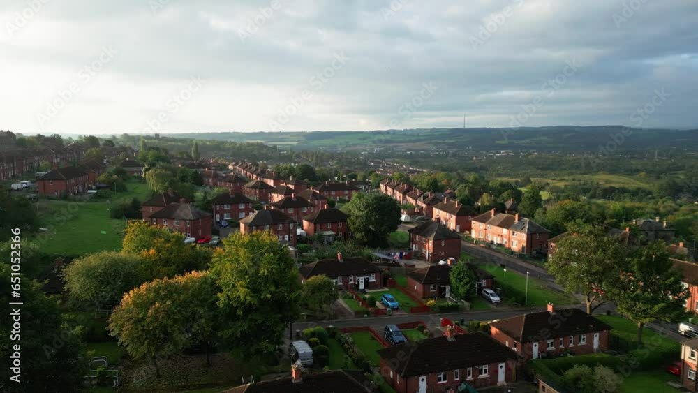 Yorkshire's urban life: Aerial view of a council-run housing estate with red brick houses, bathed in morning sunlight, and a lively atmosphere with people on the streets. Yorkshire's urban life: Aerial view of a council-run housing estate with red brick houses, bathed in morning sunlight, and a lively atmosphere with people on the streets.