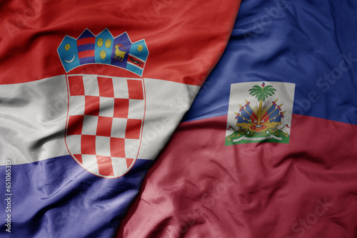 big waving national colorful flag of croatia and national flag of haiti .