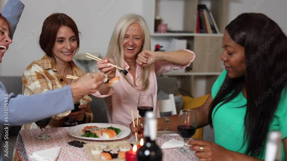 group of diverse women eating sushi at home group of diverse women eating sushi at home