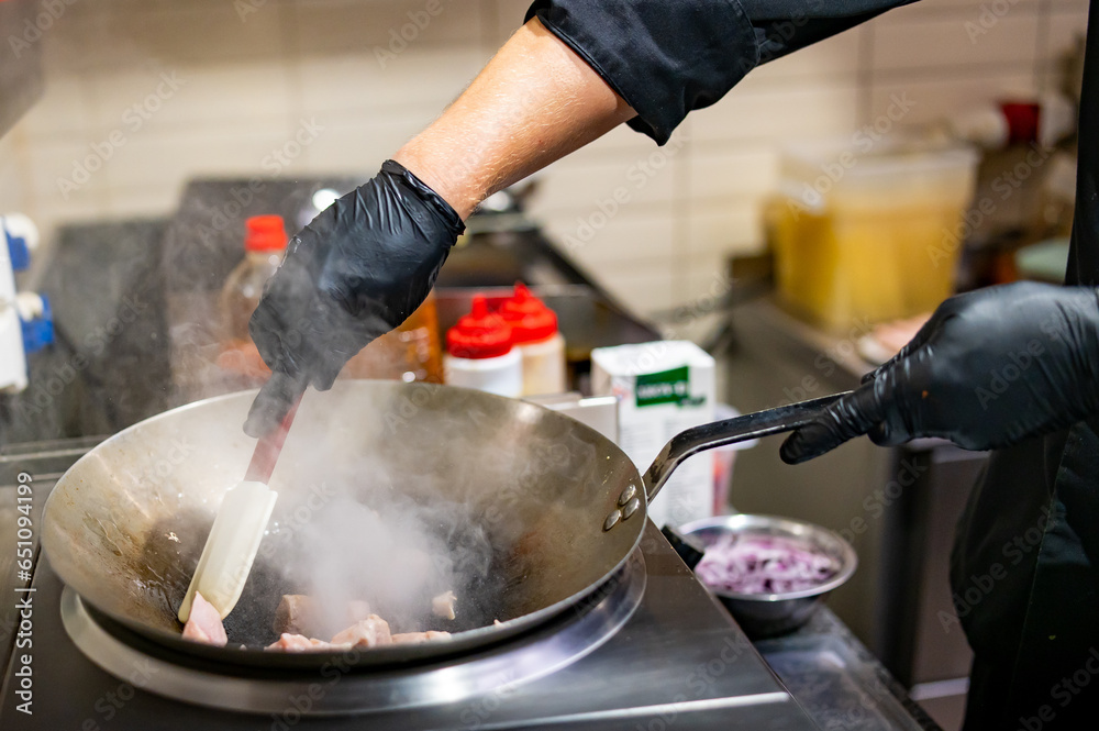 Fototapeta premium Professional chef cooking chicken curry food in wok pan on kitchen