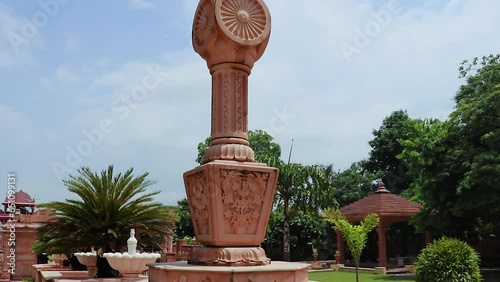 artistic red stone jain god holy pillar with bright blue sky at morning from unique angle video is taken at Shri Digamber Jain Gyanoday Tirth Kshetra, Nareli, Ajmer, Rajasthan, India. photo