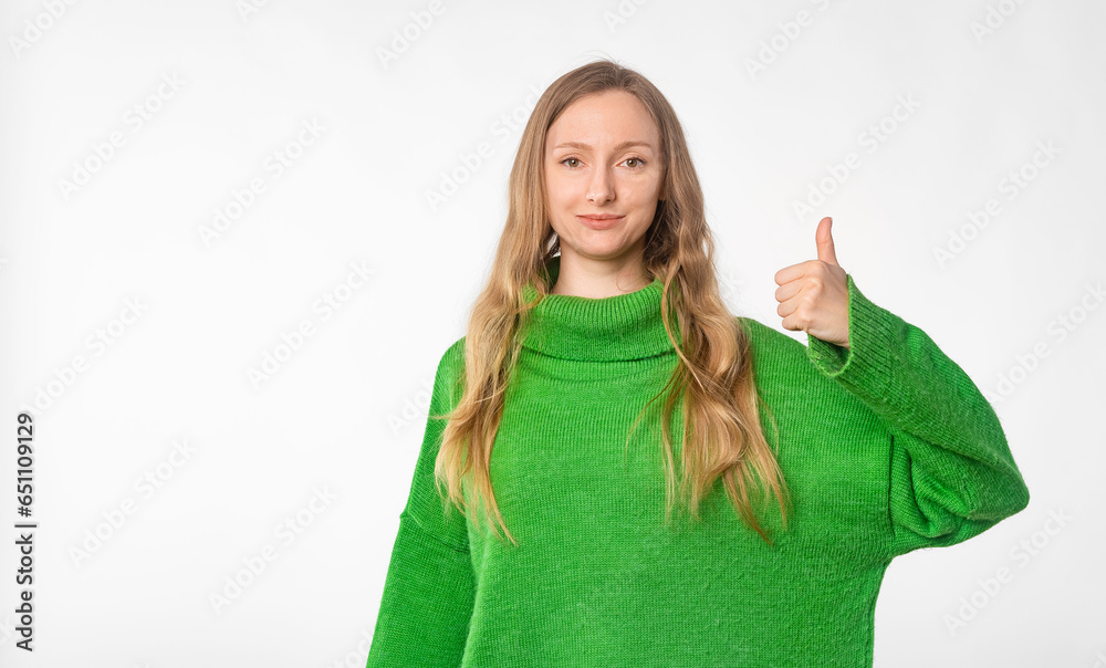 Portrait of happy woman showing thumb up, recommends smth good, approve and like brand or company, standing in green cozy sweater over white background Portrait of happy woman showing thumb up, recommends smth good, approve and like brand or company, standing in green cozy sweater over white background