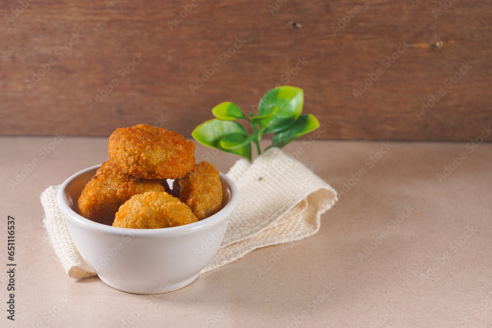 Circle chicken nuggets in white bowl on wooden background on a wooden background. Nugget Lingkaran