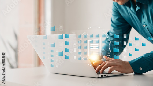 Document management system concept, businessman use laptop management folder and document icon software, searching and managing files online document database, for efficient archiving company data.