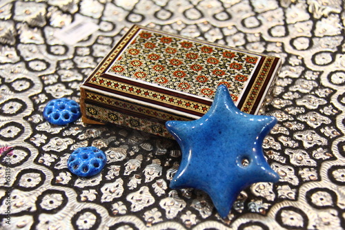 A wooden box of khatam with a blue ceramic star photo