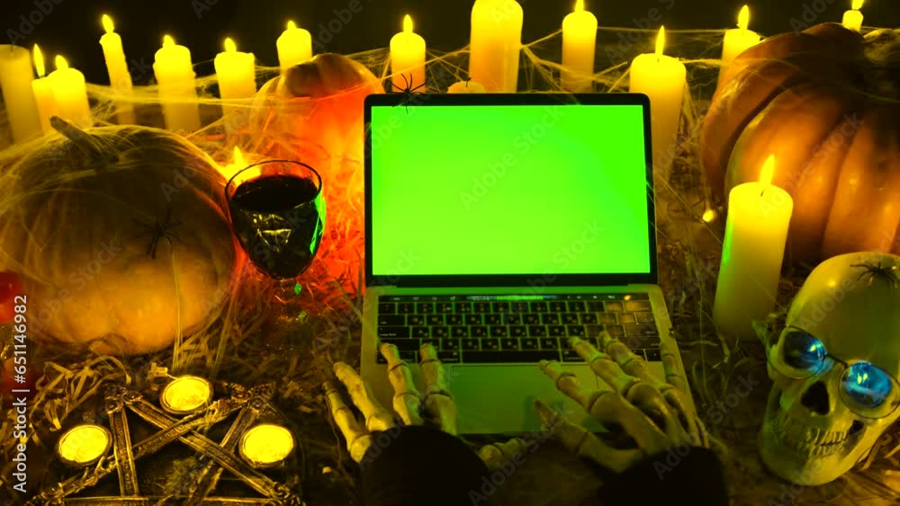 Close up. Bony monster hands typing at laptop keyboard with green