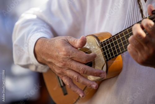 Close-up of a Canarian man playing a traditional timple (small guitar) photo