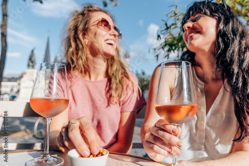 smiling ladies enjoy quality time having conversation and drinking wine photo