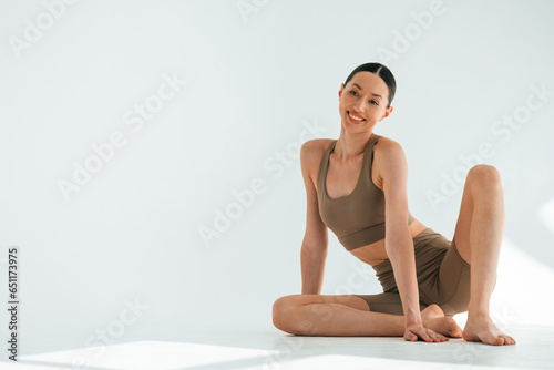 Smiling, feeling good. Young woman with slim body type is in fitness clothes in the studio