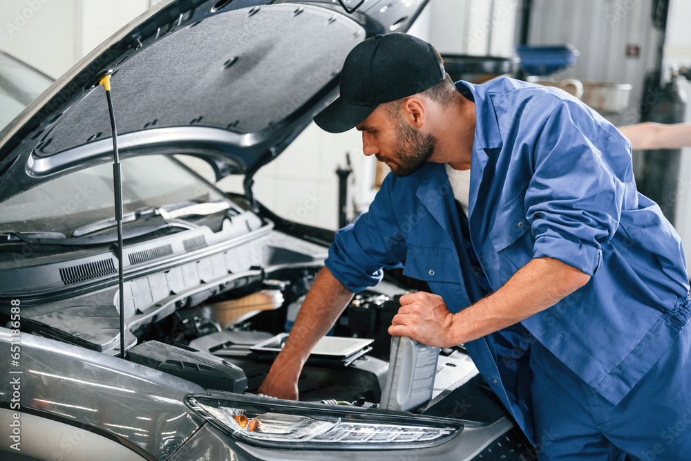 Process of changing the oil. Auto mechanic working in garage. Repair service Process of changing the oil. Auto mechanic working in garage. Repair service