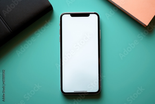 Flat lay mockup of a phone with a clean white screen and notebooks lies on a turquoise background photo