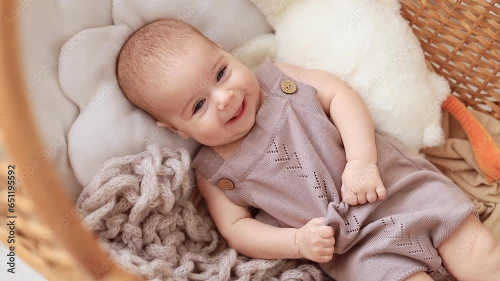 a baby girl of six months in the nursery in a wicker crib cradle at home with a soft toy smiling or laughing, a smiling little child with a toy in her hands on the bed in the bedroom a baby girl of six months in the nursery in a wicker crib cradle at home with a soft toy smiling or laughing, a smiling little child with a toy in her hands on the bed in the bedroom