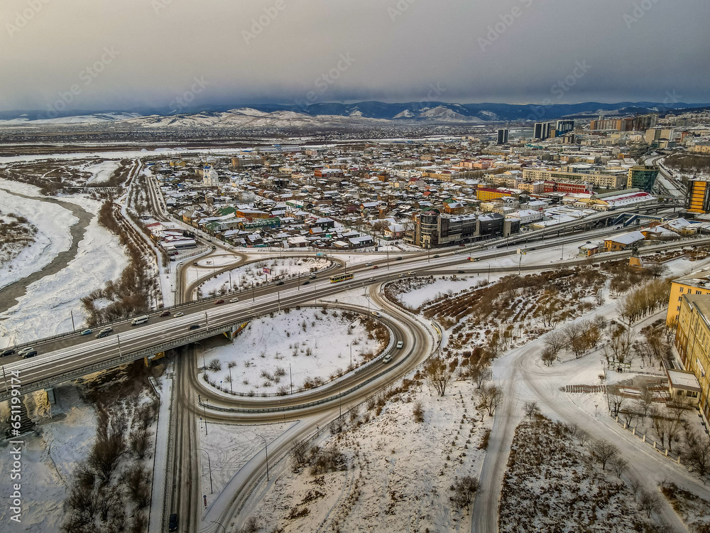 The car bridge and junction over the frozen Selenga river in the Siberian town of Ulan-Ude, Buryatiya, Russia, with the aerial panorama view during the cloudy winter day.
