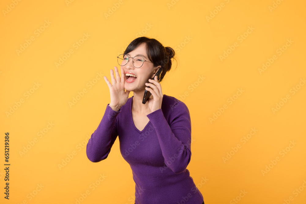 Connect, shop, and succeed online with cheerful lady, wearing a purple shirt and eyeglasses, and her smartphone. Embrace the beauty of digital communication against a yellow background Connect, shop, and succeed online with cheerful lady, wearing a purple shirt and eyeglasses, and her smartphone. Embrace the beauty of digital communication against a yellow background