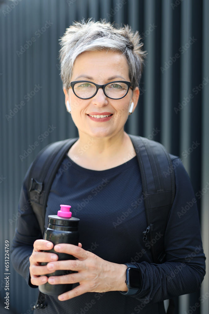 Fototapeta premium A cheerful and elegant senior woman enjoys a healthy outdoor lifestyle in her 50s, radiating happiness and vitality.