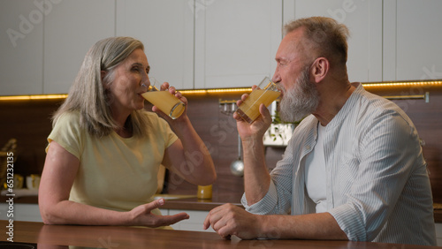 Foto Happy middle-aged old senior couple Caucasian family woman and man drinking oran