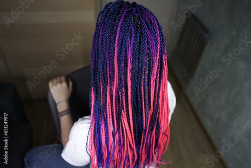The master demonstrates to students how to weave an African braid with Kanekalon on a model, afro-locks on a frame, frame hairstyles, afro-curls, a base for hair extensions photo
