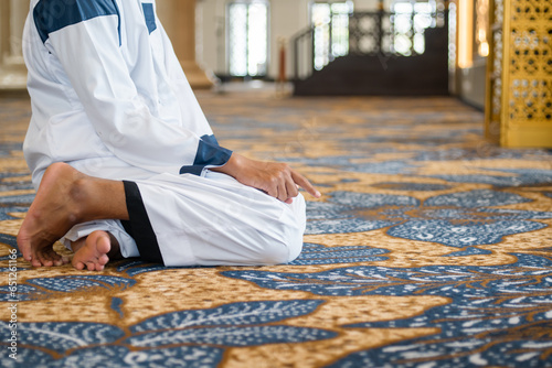 Muslim men praying in Tashahhud posture photo