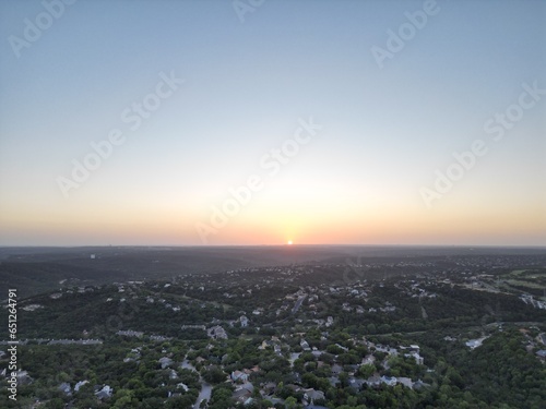 Sunset over the city and hill country. Clear blue skies. Orange sun. Vistas and panoramas.