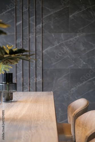 A vase of leaves on a wooden table with a modern luxury marble wall background