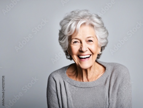 a closeup photo portrait of a beautiful elderly senior model woman with grey hair laughing and smiling with clean teeth. used for a dental ad. isolated on white background. 
