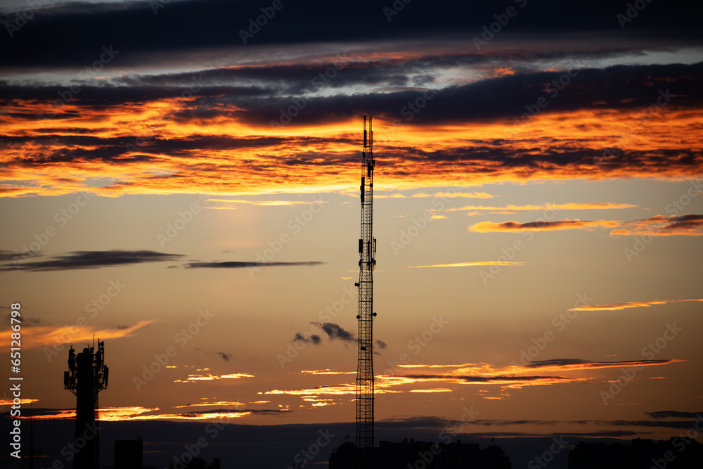 Dark, clear silhouettes of roofs of houses with chimneys and pipes in rays of setting sun. Sunset in city. Silhouette City landscape in backlight of sunset. Landscape Sky. Dark, clear silhouettes of roofs of houses with chimneys and pipes in rays of setting sun. Sunset in city. Silhouette City landscape in backlight of sunset. Landscape Sky.