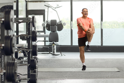 Mature man in sportswear stretching leg photo