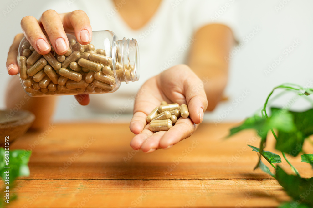 Capsules of plant origin held in hand, nature, laboratory, science of dietary supplements