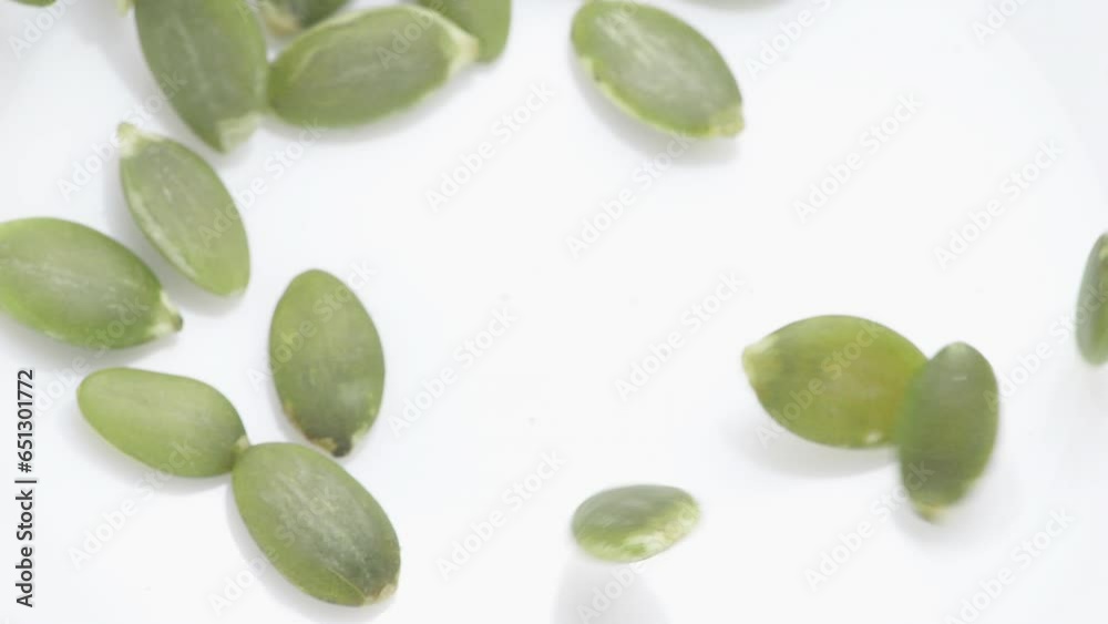 Pouring pumpkin seeds green hull-less to nibble. Slow motion. Pouring pumpkin seeds green hull-less to nibble. Slow motion.