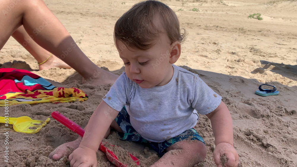 Happy ecstatic baby boy infant at beach playing with sand Happy ecstatic baby boy infant at beach playing with sand