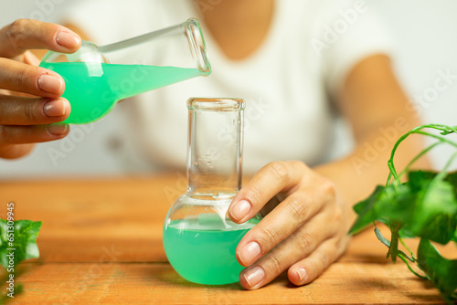 Scientist preparing a new recipe for plant medicines, medical research, natural laboratory, vials with liquid