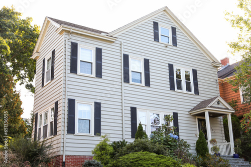 suburban house under stormy clouds, symbolizing the housing crisis, rising mortgage rates, and the struggle of homeownership in turbulent times