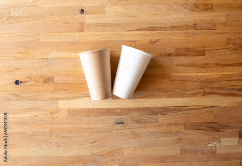 paper cup of coffee nature frindely on wooden background from top view with mock up space 
