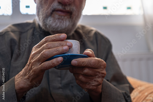 Old man drinking coffee with smile on his face photo