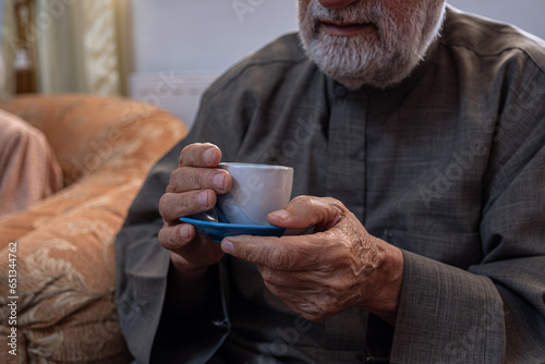 Old man drinking coffee with smile on his face photo