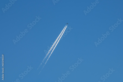 The airplane is flying in the blue sky. 