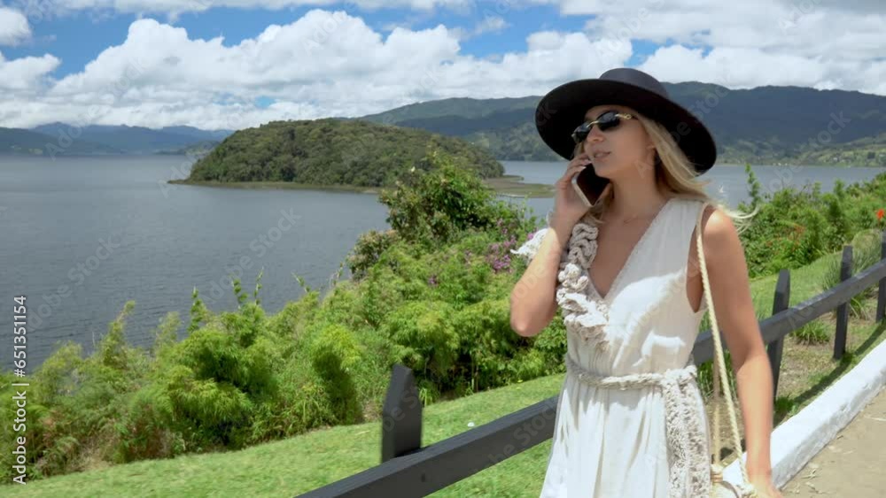 CAUCASIAN WOMAN TALKING ON A CELL PHONE IN LAGUNA DE LA COCHA PASTO NARIÑO. WOMAN USING TECHNOLOGY