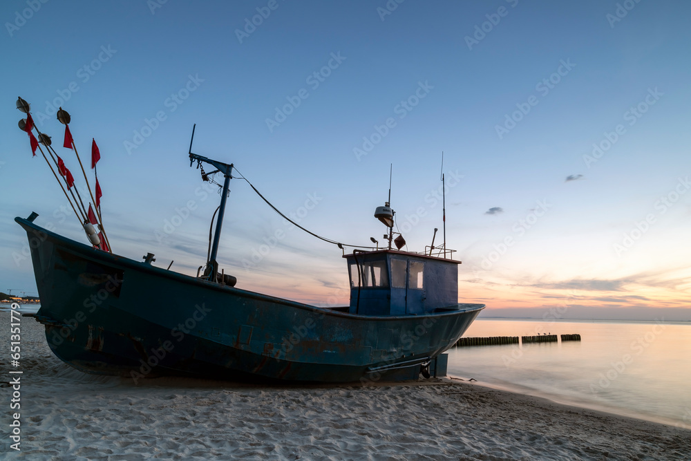 fishing boat on the beach during sunset