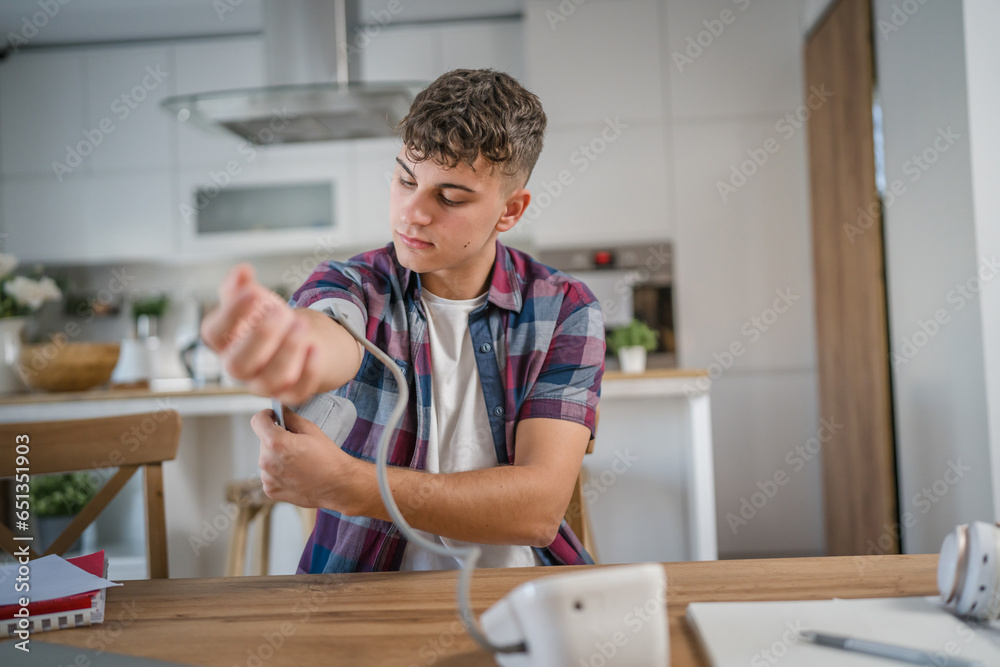 one teenager caucasian man measure check blood pressure at home alone one teenager caucasian man measure check blood pressure at home alone