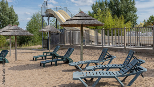 Beach by the side of a pool with water silde photo