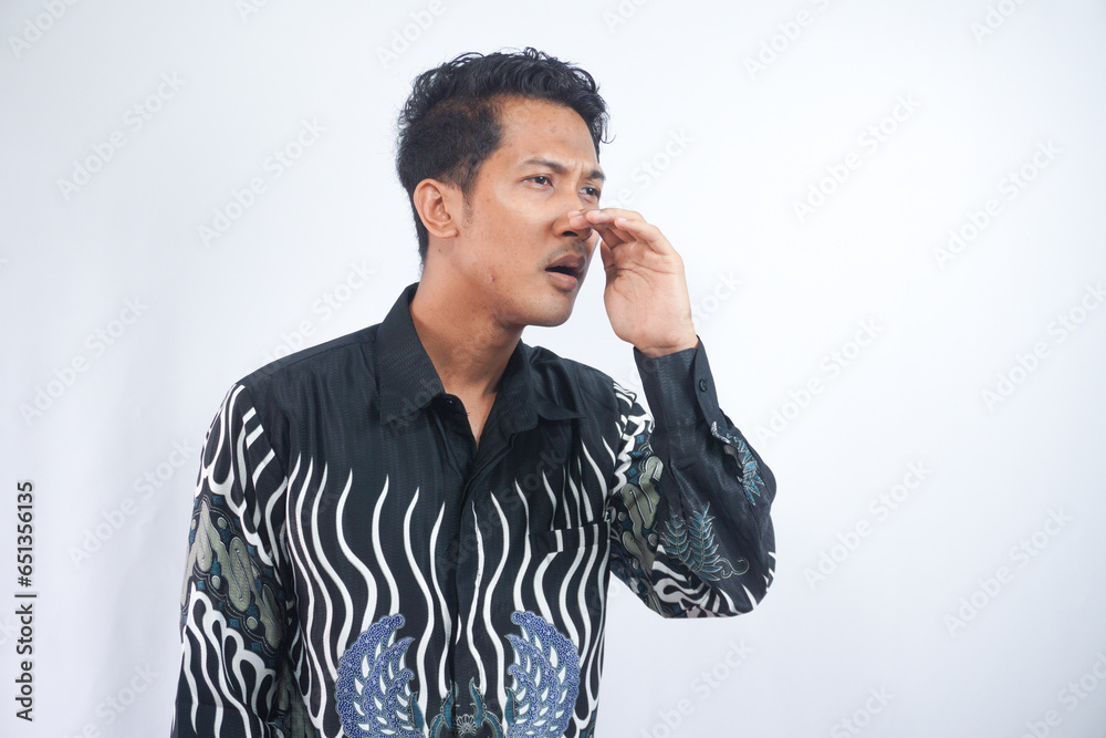 Young asian man wearing batik whispering and gossiping, side view isolated on white Young asian man wearing batik whispering and gossiping, side view isolated on white