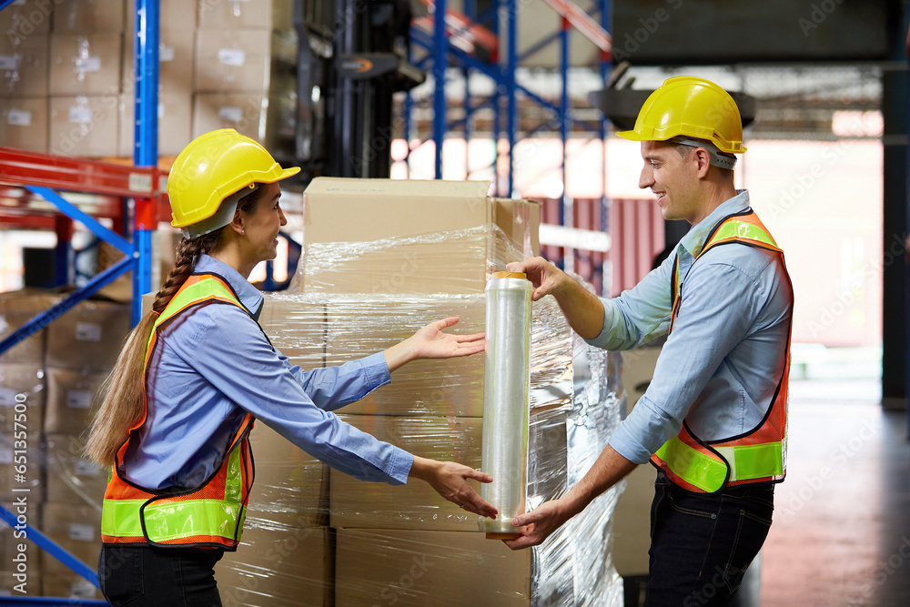 factory workers or warehouser wrapping stretch film parcel on pallet covered cardboard boxed in warehouse storage factory workers or warehouser wrapping stretch film parcel on pallet covered cardboard boxed in warehouse storage