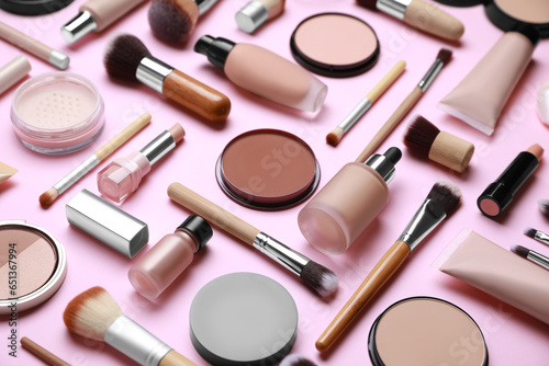 Face powders and other decorative cosmetic products on pink background