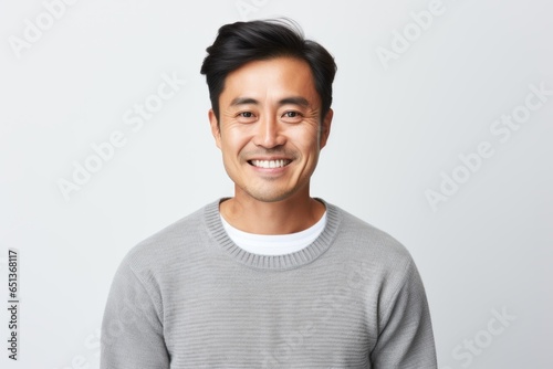 Medium shot portrait photography of a happy Vietnamese man in his 30s wearing a cozy sweater against a white background