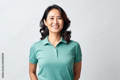 Medium shot portrait photography of a Vietnamese woman in her 40s wearing a sporty polo shirt against a white background
