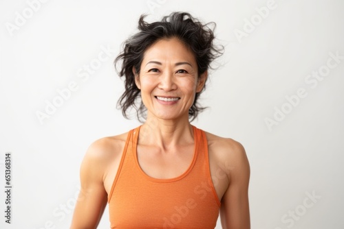 Medium shot portrait photography of a Vietnamese woman in her 40s wearing a sporty tank top against a white background