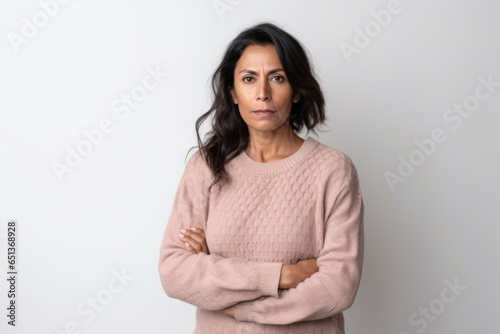 Medium shot portrait photography of a serious Peruvian woman in her 40s wearing a cozy sweater against a white background © Robert MEYNER